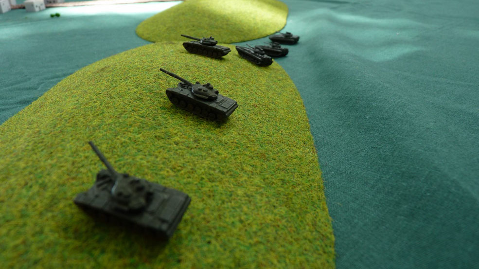 A platoon of T72s takes up position behind the crest